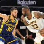 Lakers forward LeBron James (23) handles the ball against Golden State Warriors guard Stephen Curry (30)