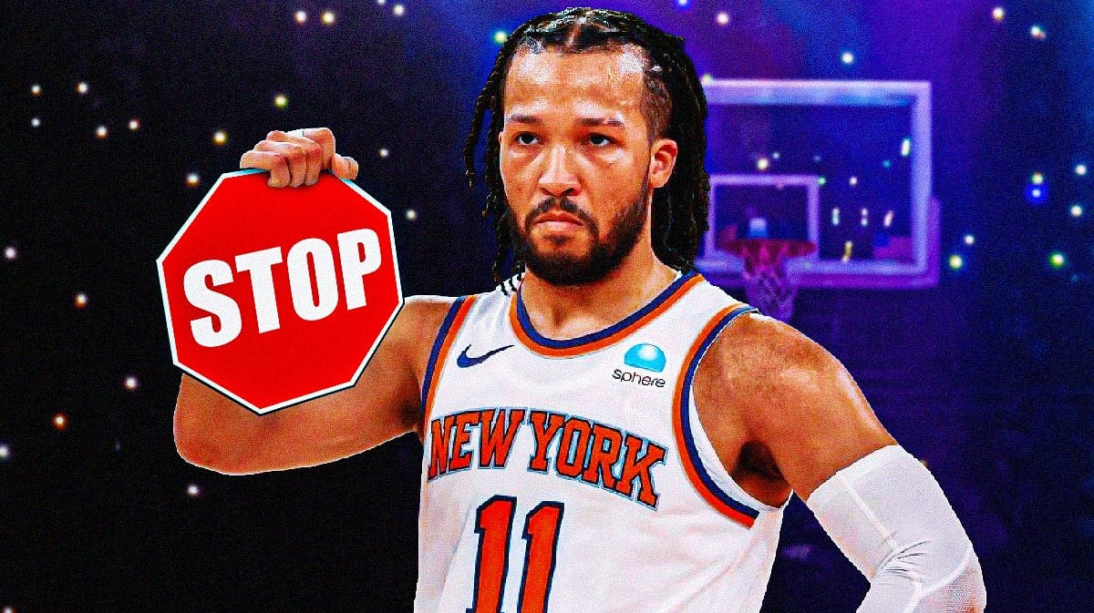 Knicks' Jalen Brunson holding a stop sign.