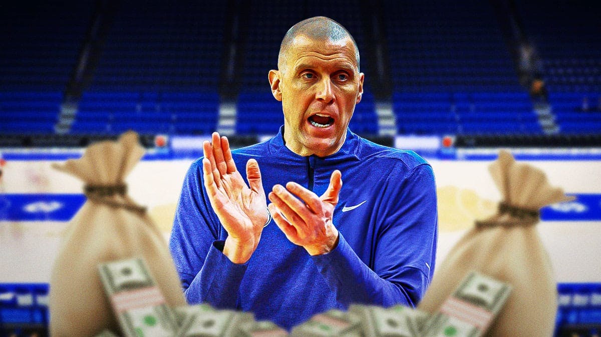 Kentucky basketball coach Mark Pope with money bags around him.