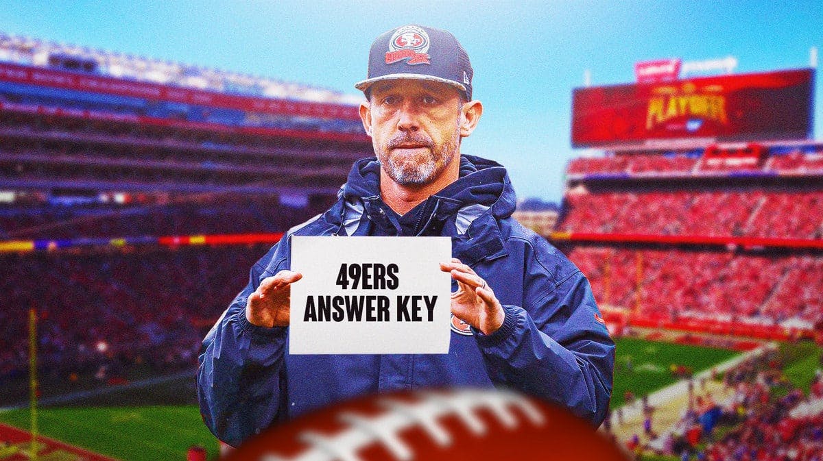 Kyle Shanahan holding a piece of paper with "49ers Answer Key" written on the paper