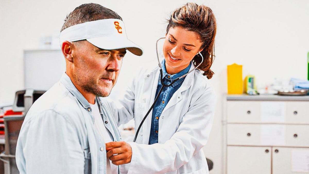 Lincoln Riley being checked by a doctor