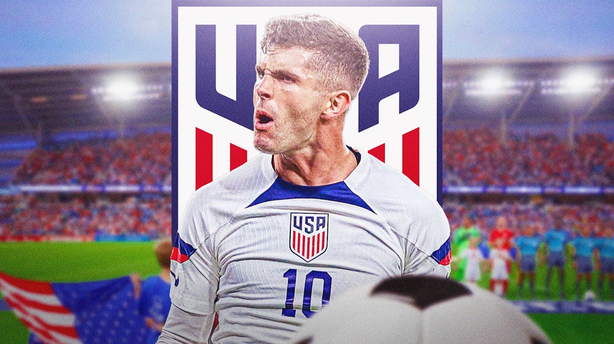 Christian Pulisic celebrating in front of the USMNT logo