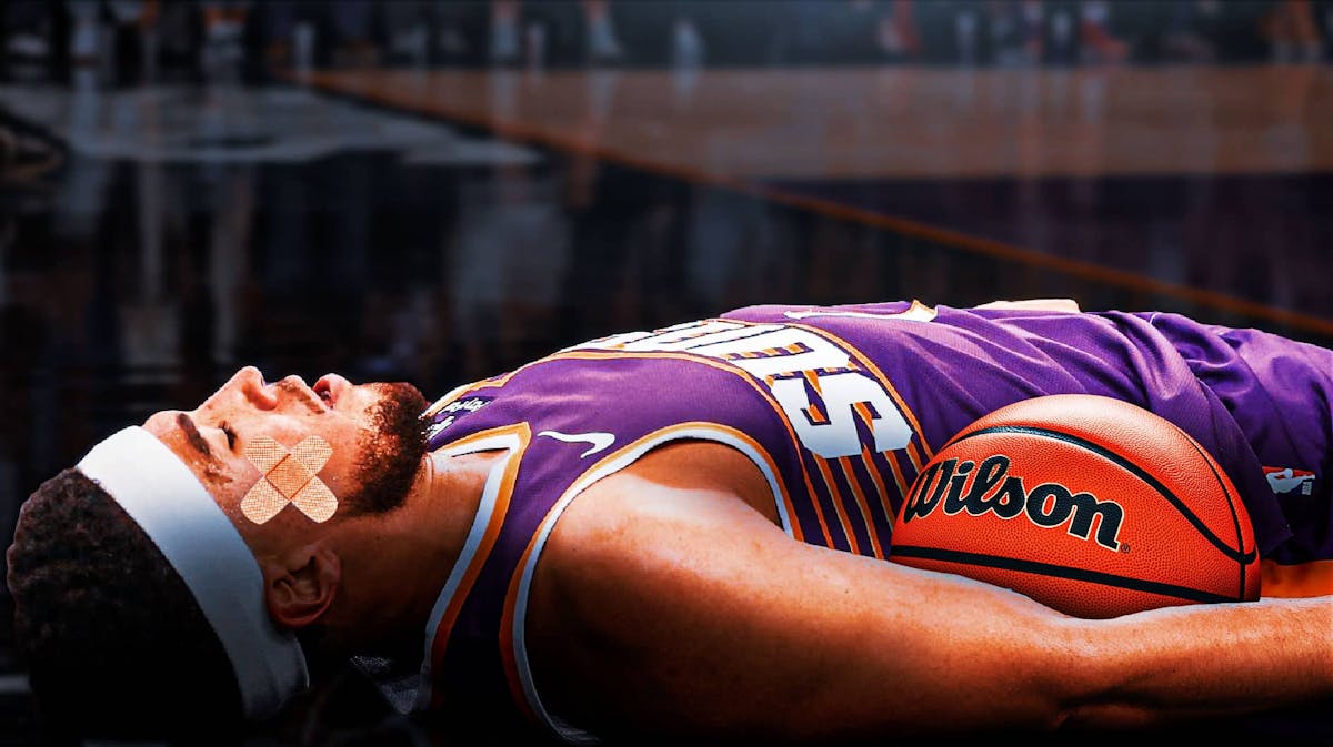 Phoenix Suns guard Devin Booker lies on the ground with bandage on head.