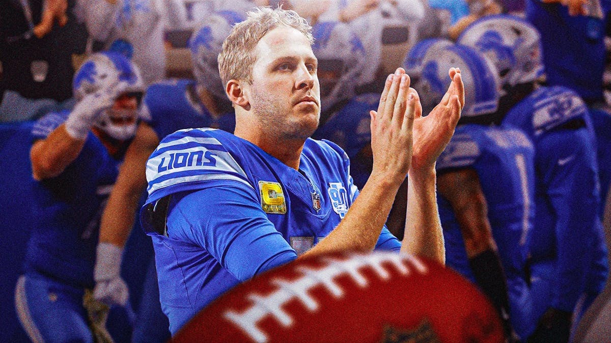 Detroit Lions quarterback Jared Goff clapping in the foreground. In the background, Lions players.