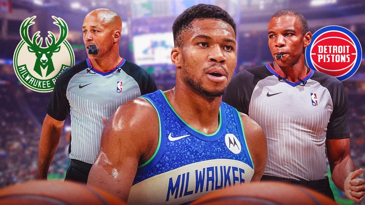 Giannis Antetokounmpo in middle looking stern, NBA ref on each side of him, MIL Bucks and DET Pistons logos, basketball court in background