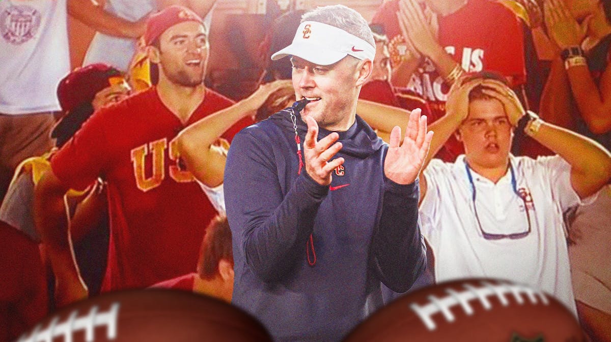 USC football coach Lincoln Riley in foreground, clapping hands. In the background, USC fans look stunned.