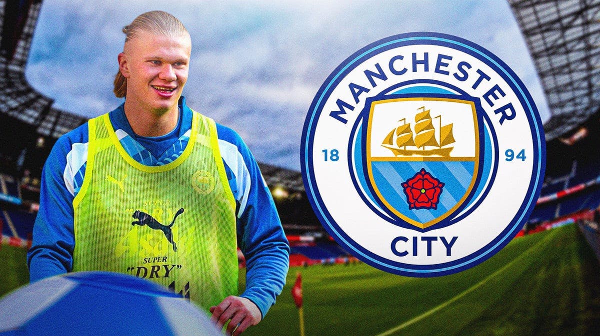 Erling Haaland laughing in front of the Manchester City logo