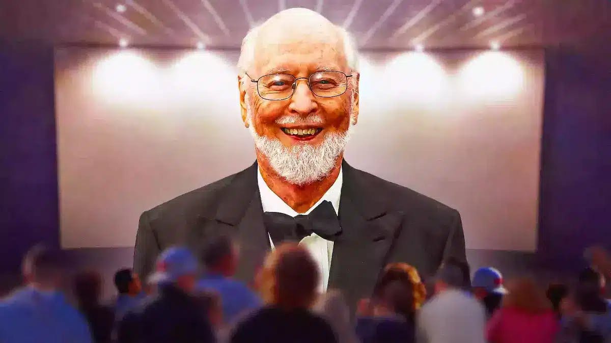 John Williams with a movie screen behind him.