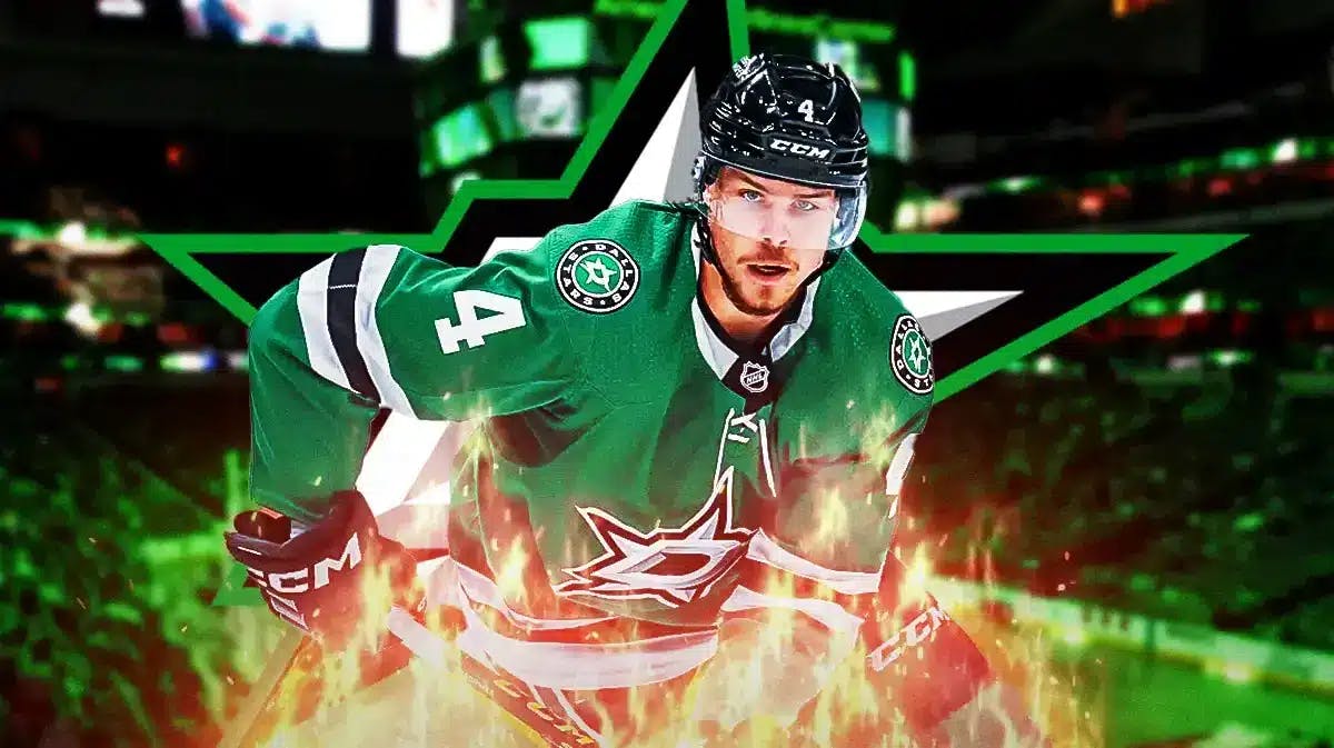 Miro Heiskanen in middle of image looking happy with fire around him, DAL Stars logo, hockey rink in background