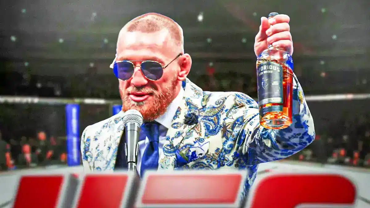 Conor McGregor smiling and holding a Proper No. Twelve Irish whiskey bottle in a UFC arena