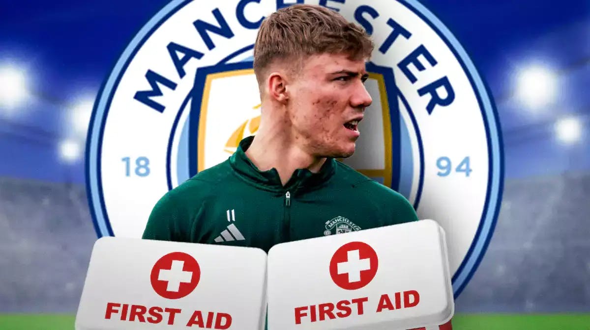 Rasmus Hojlund injured in front of the Manchester United logo