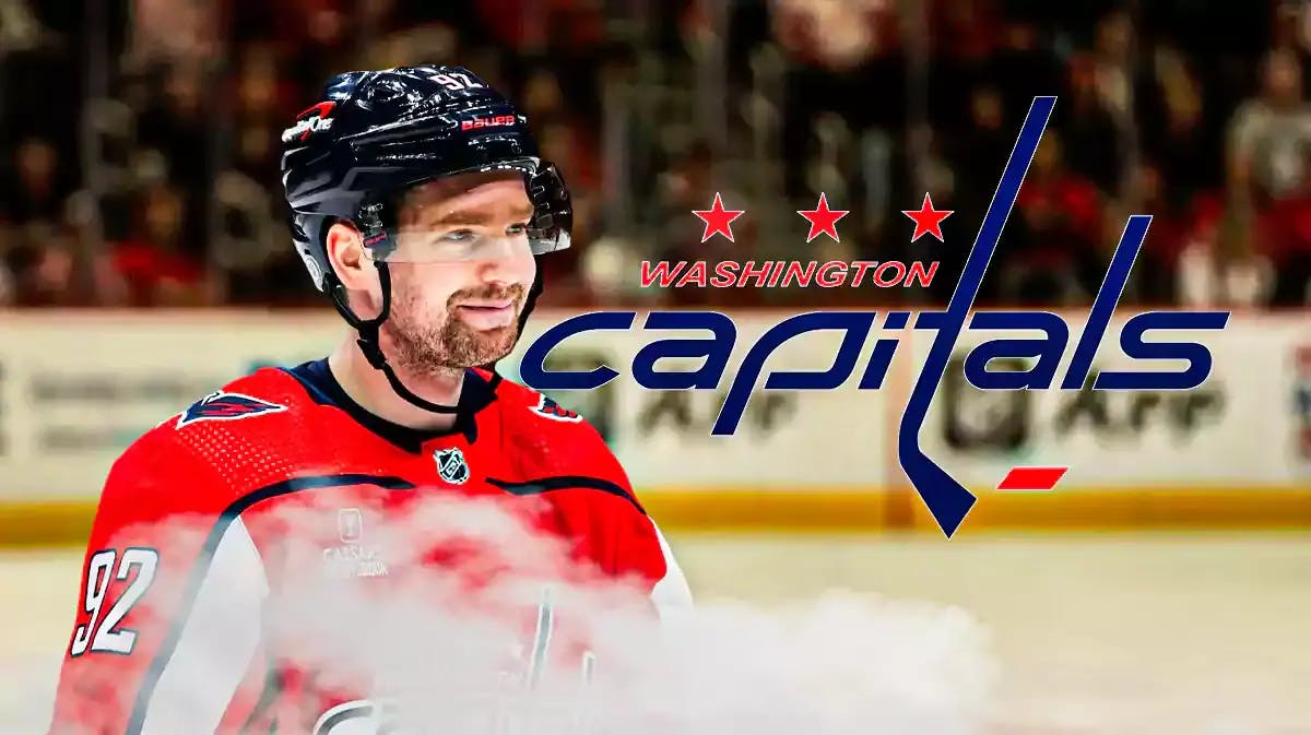 Evgeny Kuznetsov looking hopeful, WSH Capitals logo, hockey rink in background