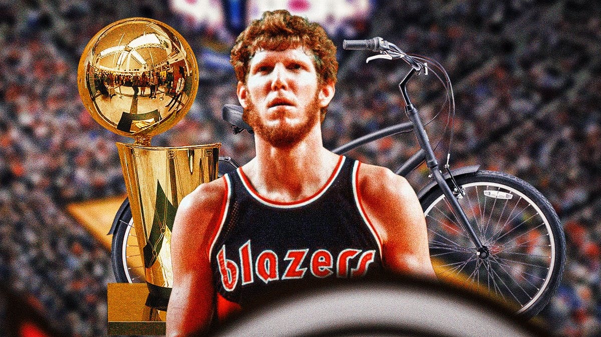 Bill Walton in a Blazers jersey with the NBA championship trophy next to an adult bike.
