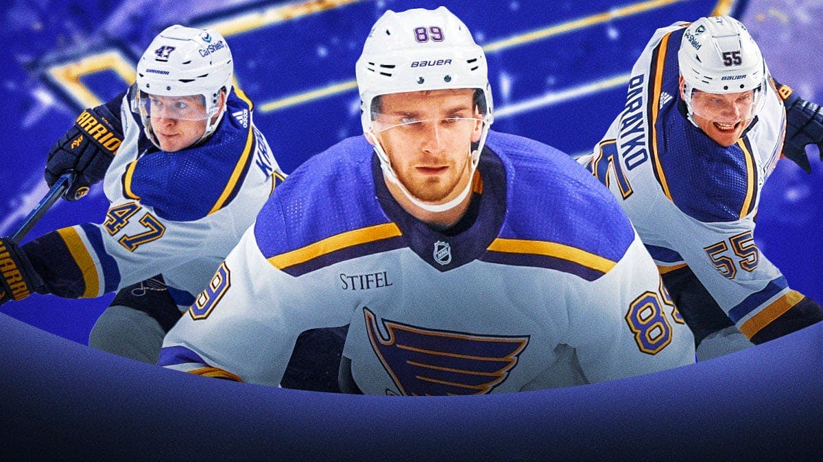 Pavel Buchnevich in middle of image looking stern, Torey Krug and Colton Parayko on either side, St. Louis Blues logo, hockey rink in background