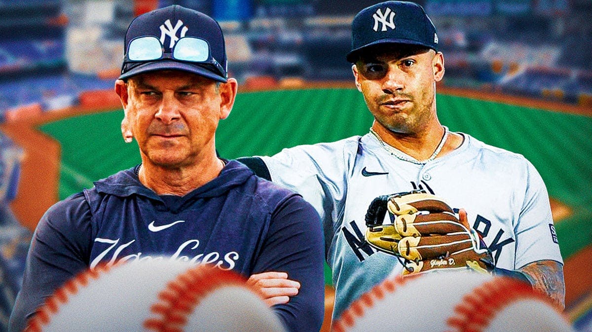 Aaron Boone next to Gleyber Torres, who's wearing a baseball glove