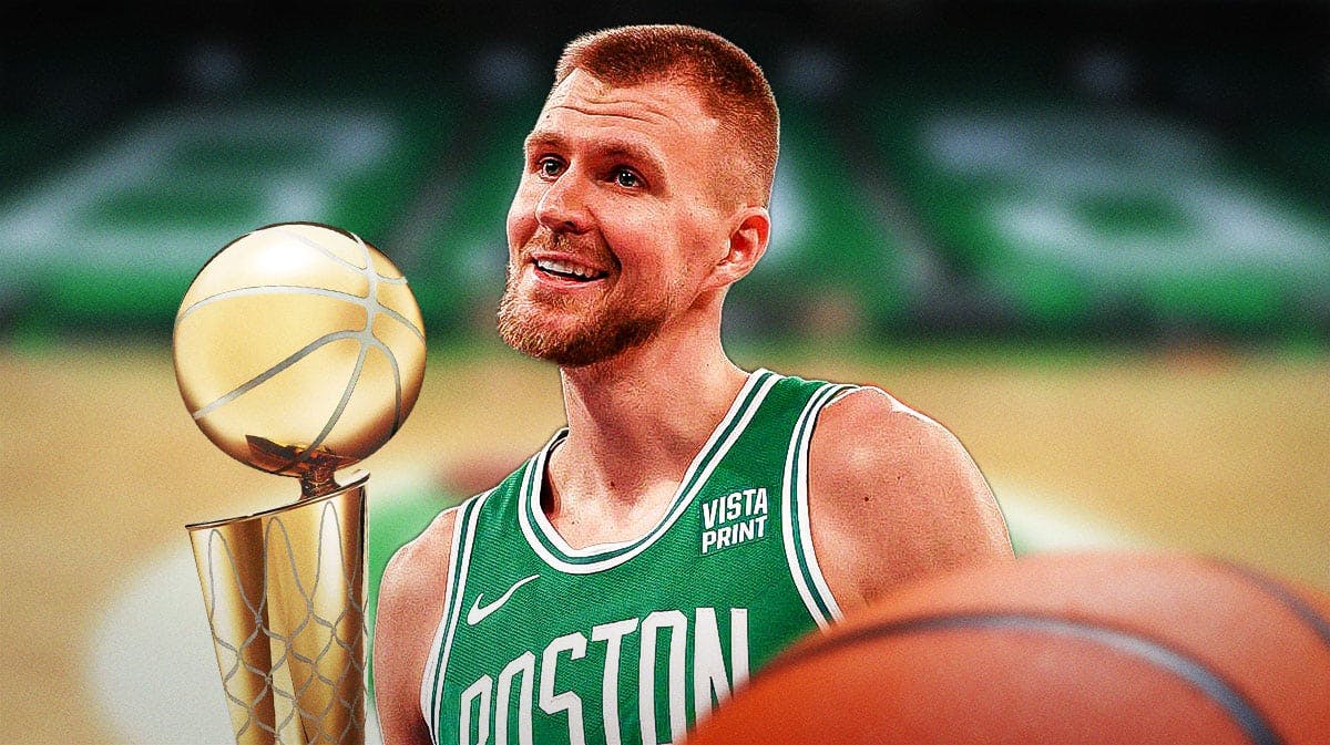 Celtics' Kristaps Porzingis next to the NBA Finals trophy