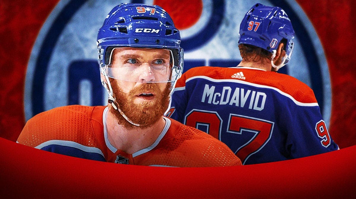 Connor McDavid in middle of image looking stern, Edmonton Oilers logo, hockey rink in background