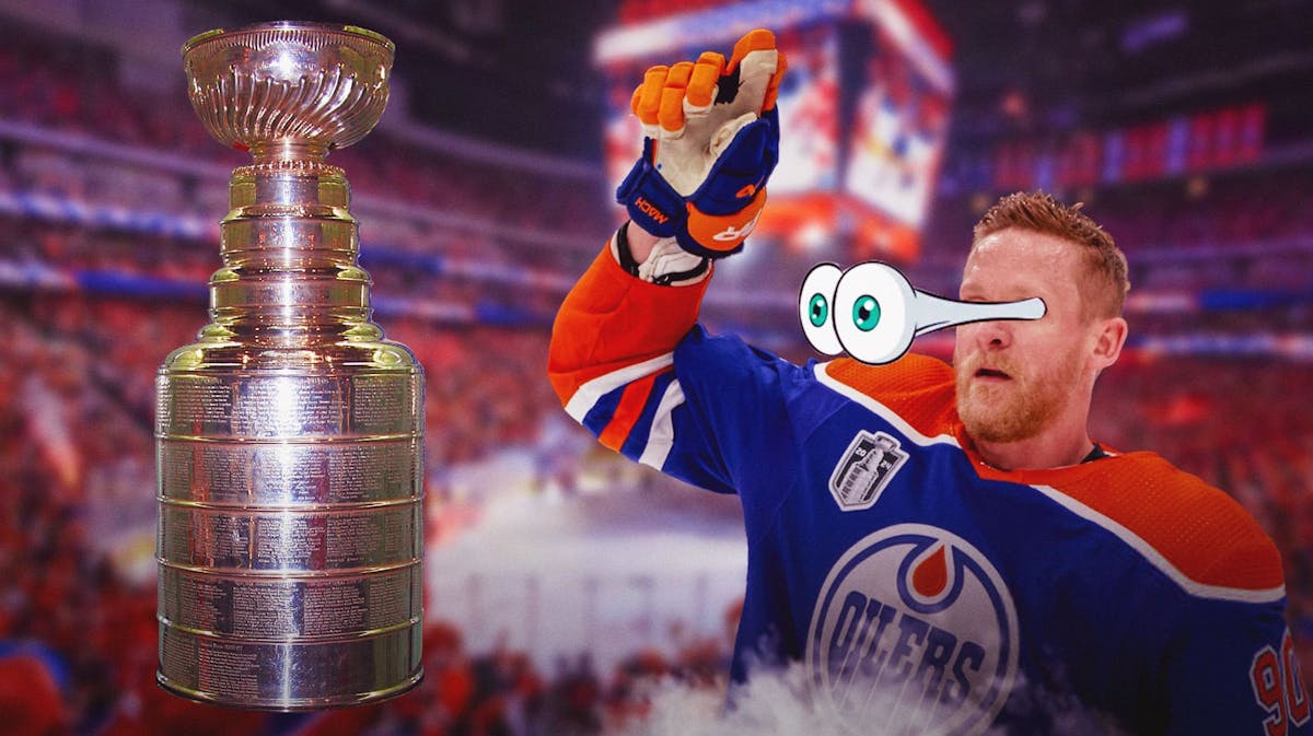 Corey Perry with big emoji eyes looking at the Stanley Cup.