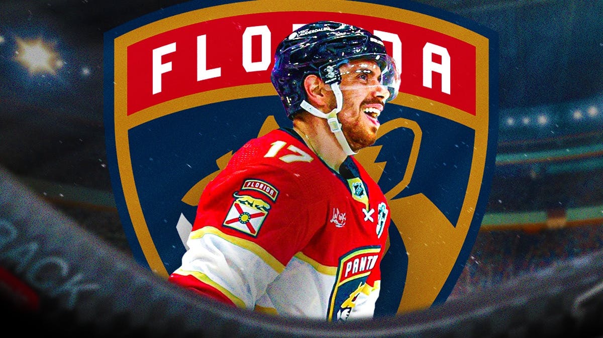 Evan Rodrigues in middle of image looking happy with fire around him, Florida Panthers logo, hockey rink in background