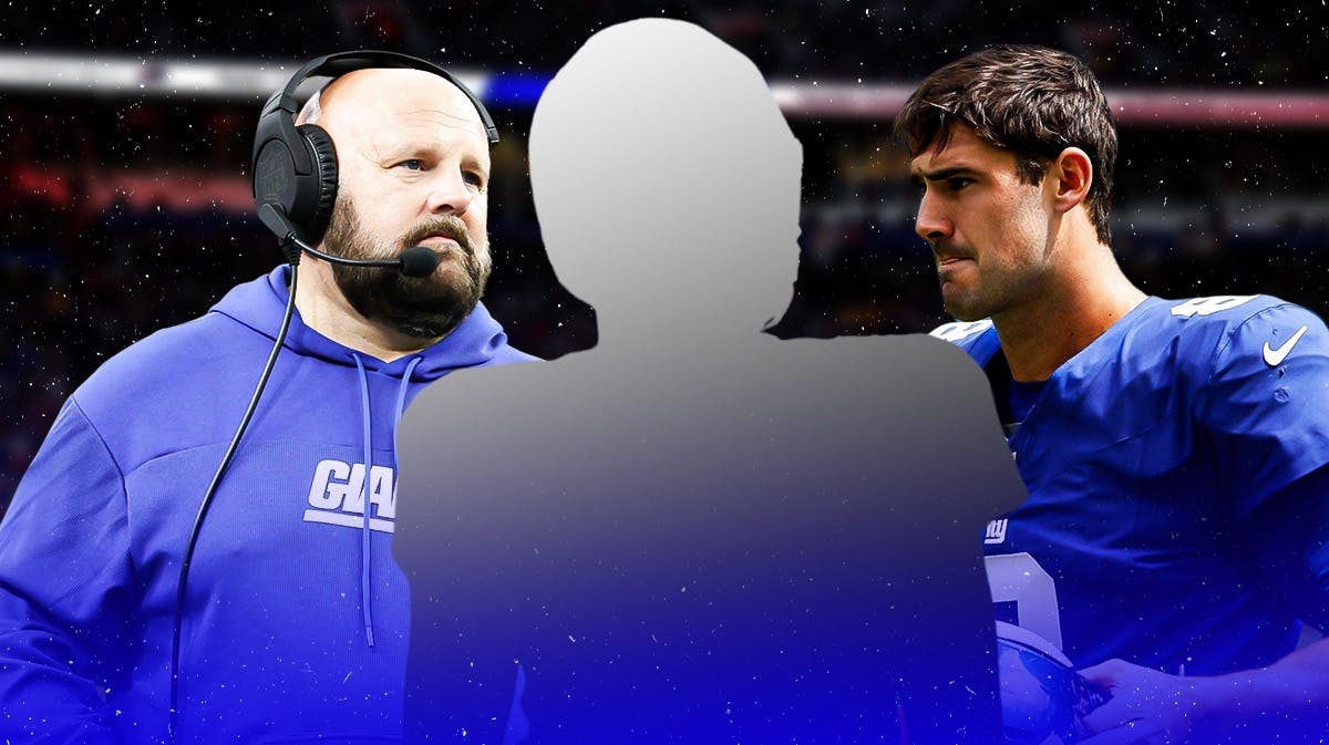 Mystery player in the middle, Coach Brian Daboll and Daniel Jones around him, New York Giants wallpaper in the background