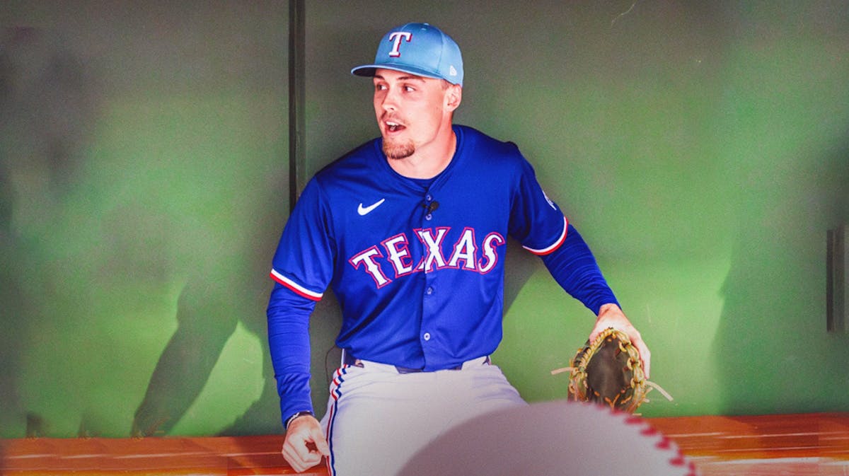 Rangers Evan Carter looking serious and sitting down in an MLB dugout.