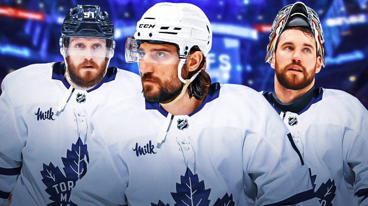 Chris Tanev, Oliver Ekman-Larsson, Anthony Stolarz in Toronto Maple Leafs uniforms. Ice rink in background.