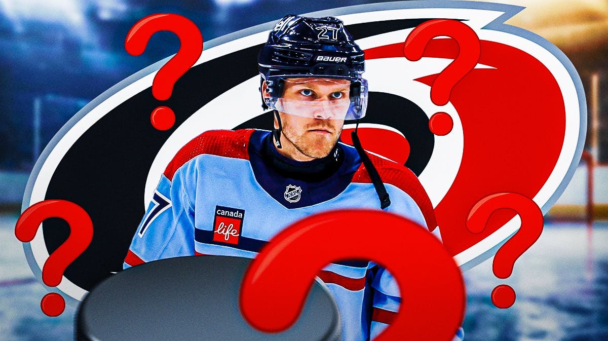 Nikolaj Ehlers in middle of image looking stern, 3-5 question marks, Carolina Hurricanes logo, hockey rink in background