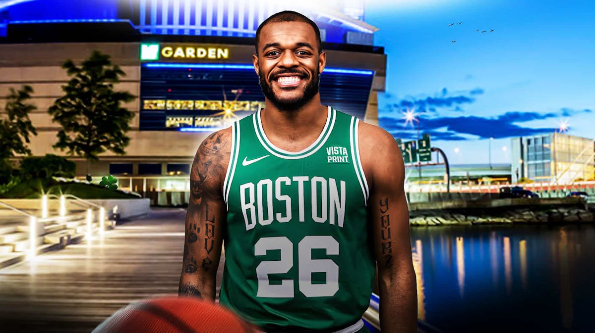 : Xavier Tillman smiling/looking happy in a Celtics jersey on a TD Garden background