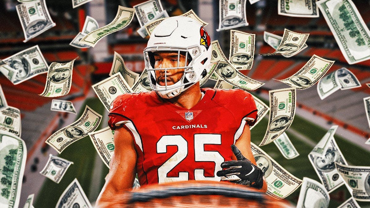 Arizona Cardinals star Zaven Collins with money around him.