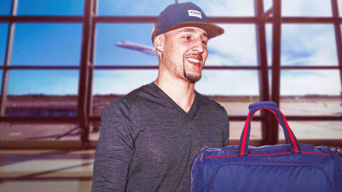 Warriors' Klay Thompson holding a suitcase at an airport.