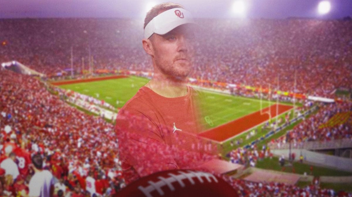 USC football coach Lincoln Riley seems to disappear with the football field in the background.