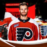 Philadelphia Flyers trade target Shane Wright wearing a Philadelphia jersey with two other players at the Wells Fargo Center on November 27, 2023