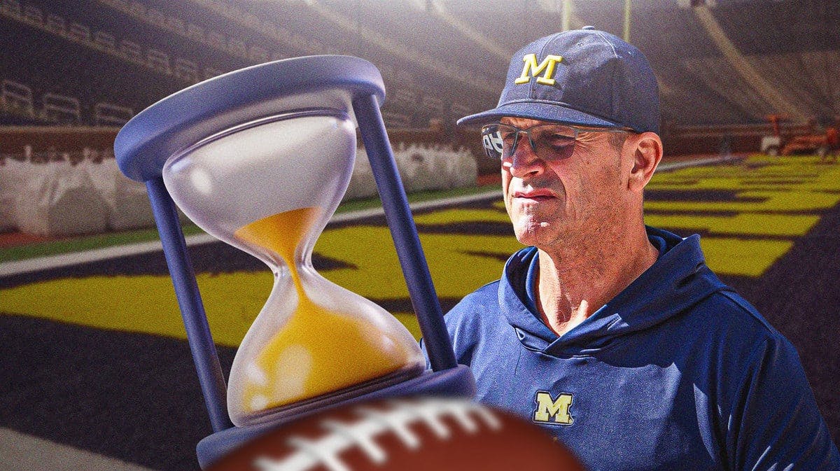 Michigan football coach Jim Harbaugh looking at the hour glass