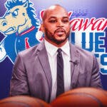 Jameer Nelson in front of the logo of the Blue Coats, the Sixers' G League affiliate