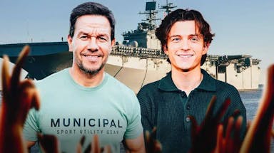 Mark Wahlberg and Tom Holland with battleship in the background.