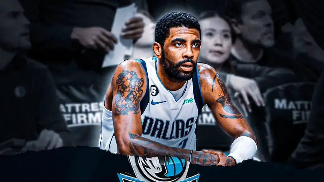 Mavs' Kyrie Irving sitting down on an NBA sideline looking serious.