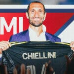Giorgio Chiellini swapping shirts with someone, the MLS logo in the air