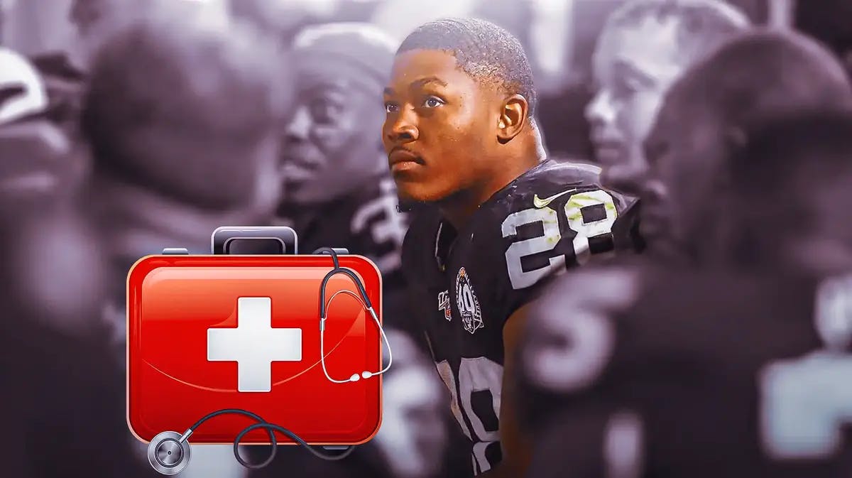 Photo: Josh Jacobs in Raiders jersey sitting on a bench with a medical kit beside him