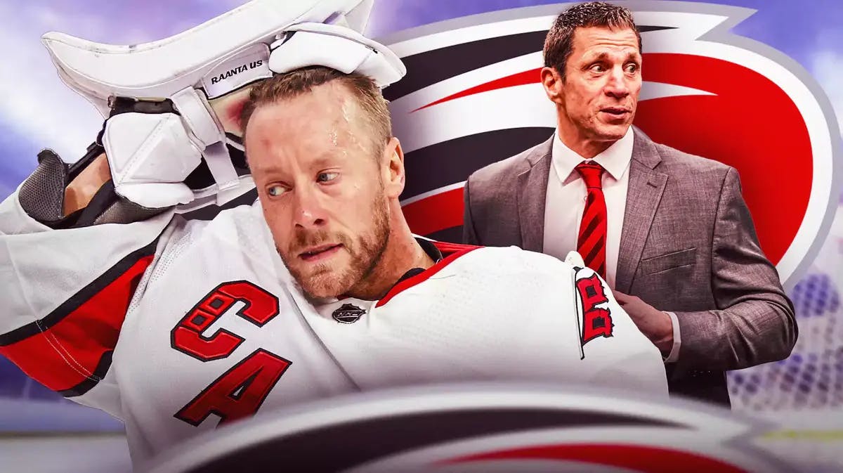 Antti Raanta in middle of image with fire around him looking happy, Rod Brind’Amour also in image, CAR Hurricanes logo, hockey rink in background