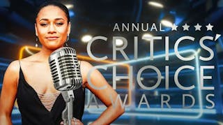 Ariana DeBose with a microphone in front of her and the Critics Choice Awards logo behind her.