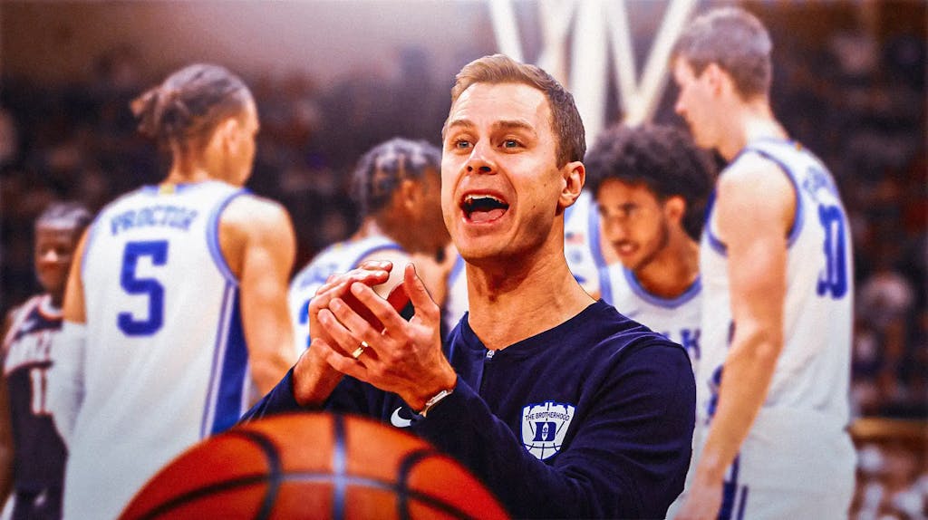 Duke basketball coach Jon Scheyer clapping his hands with excitement.