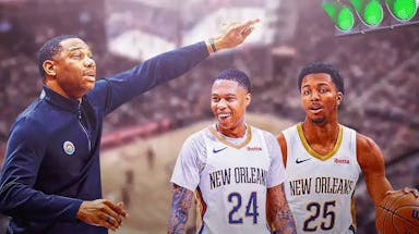 Pelicans coach Willie Green, pointing at a green light with Jordan Hawkins and Trey Murphy III under it.