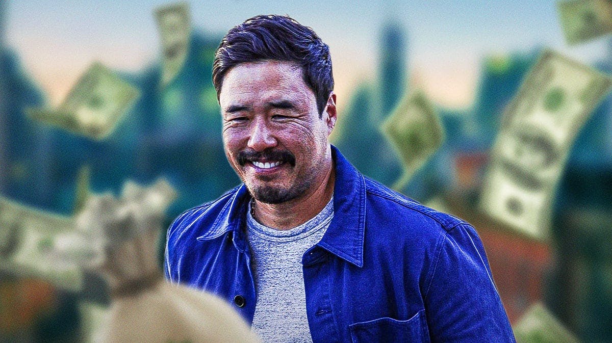 Randall Park surrounded by piles of cash.