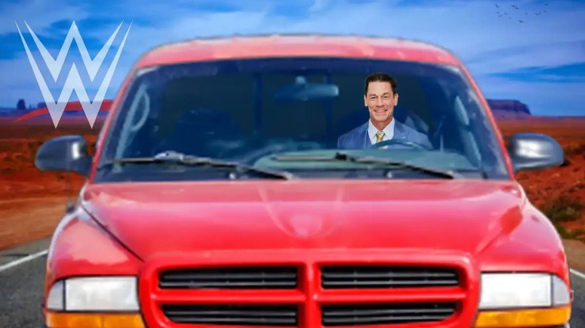 John Cena inside of a crappy car with the WWE logo on the side of it.