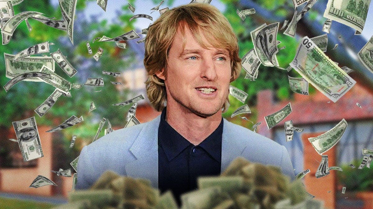 Owen Wilson surrounded by piles of cash.