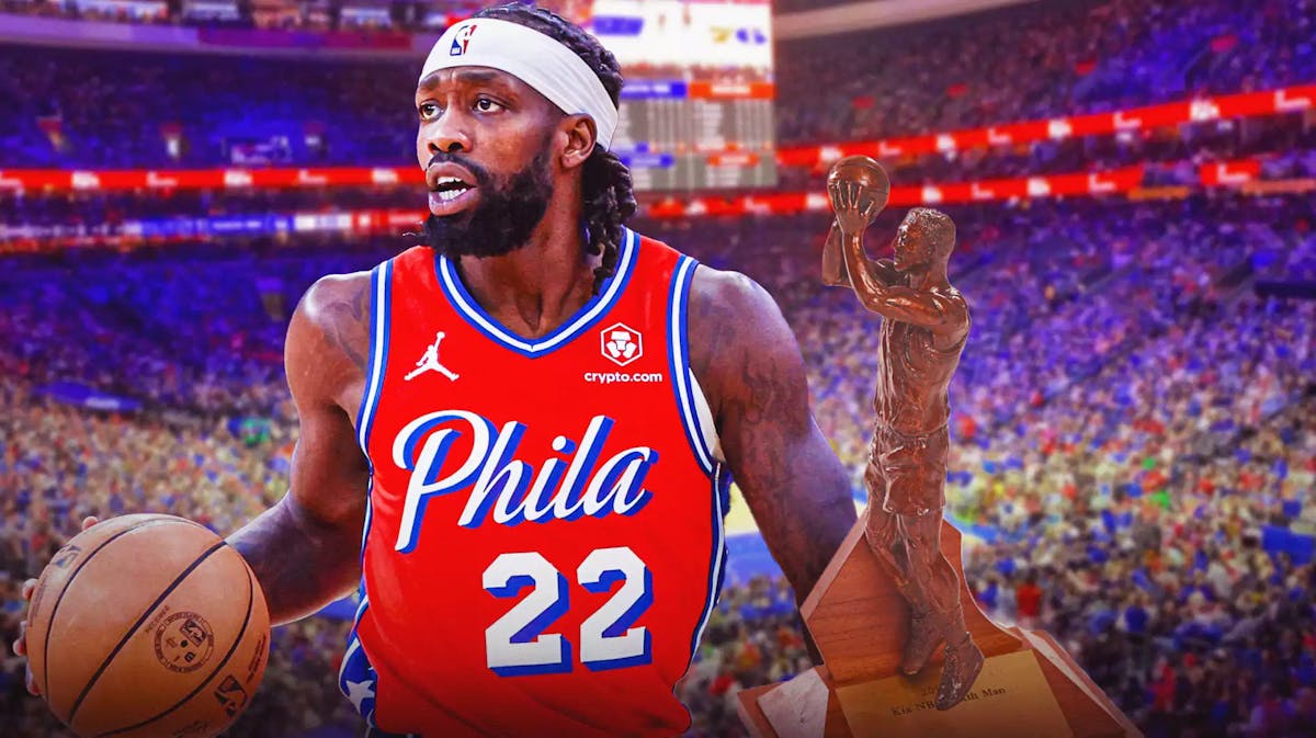 Patrick Beverley alongside the NBA's Sixth Man of the Year trophy and the Sixers arena in the background