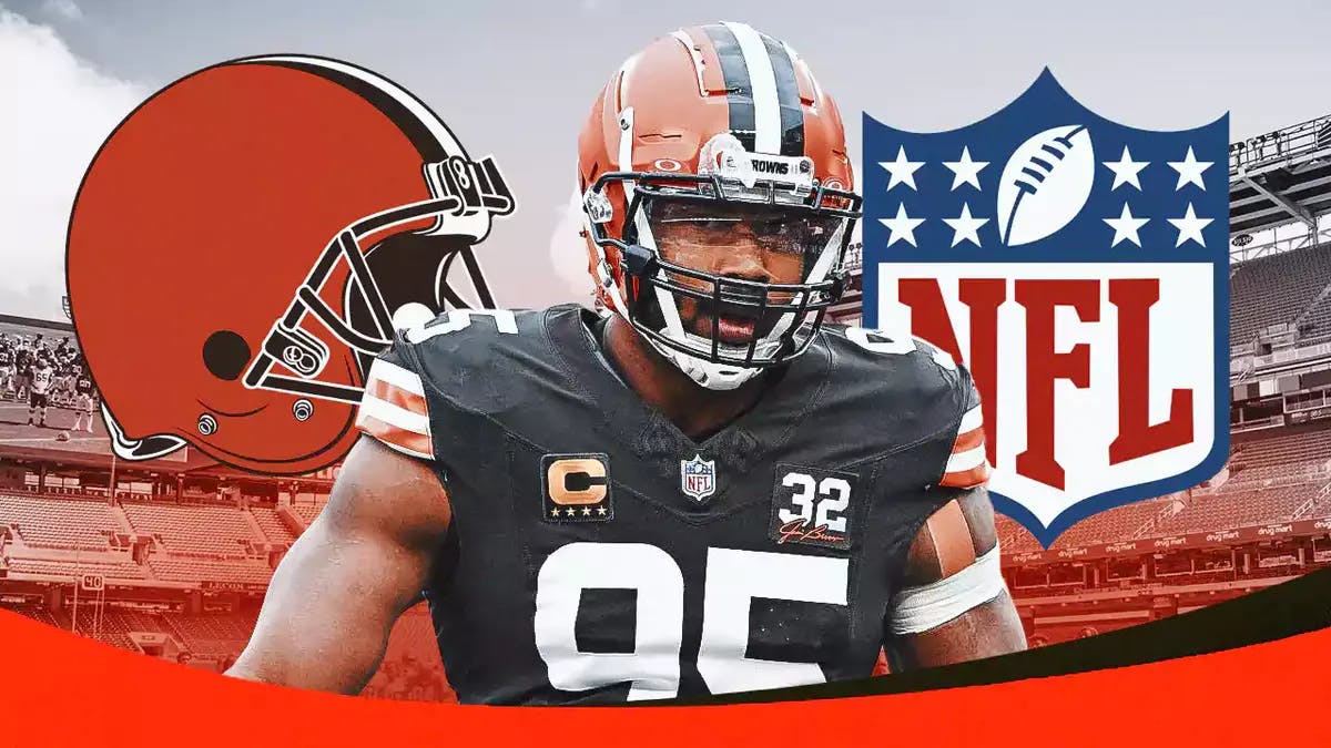 Myles Garrett stands next to Browns and NFL logo after winning Defensive Player of the Year