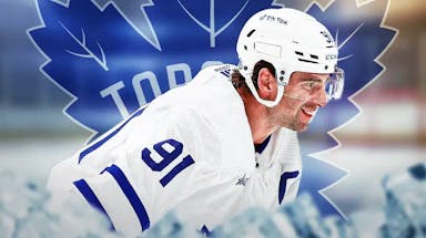 John Tavares in middle of image looking happy, TOR Maple Leafs logo, hockey rink
