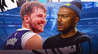 Tim Hardaway in street clothes looking at Luka Doncic
