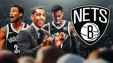 Nets head coach Kevin Ollie in front of Nic Claxton and Dennis Schroder next to a Nets logo